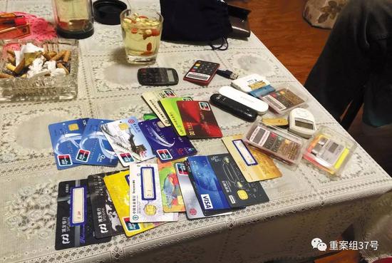 11月28日晚，燕郊东方夏威夷南岸二期10号楼501室，一名C1家长（传销头目）向刘奇等人展示自己的18 张银行卡和信用卡。    新京报记者大路摄